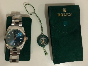 „Rolex“ на руци, потврда у торби